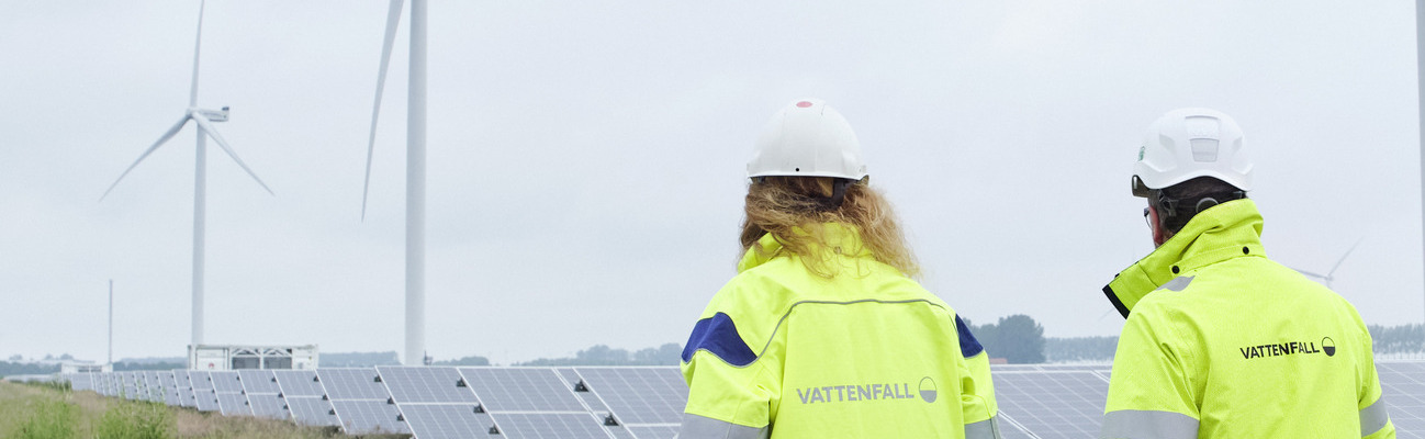 2 Vattenfall Arbeiter laufen bei Nebel durch eine Solaranlage