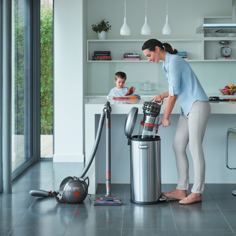 Frau mit dem Staubsauger in Wohnküche