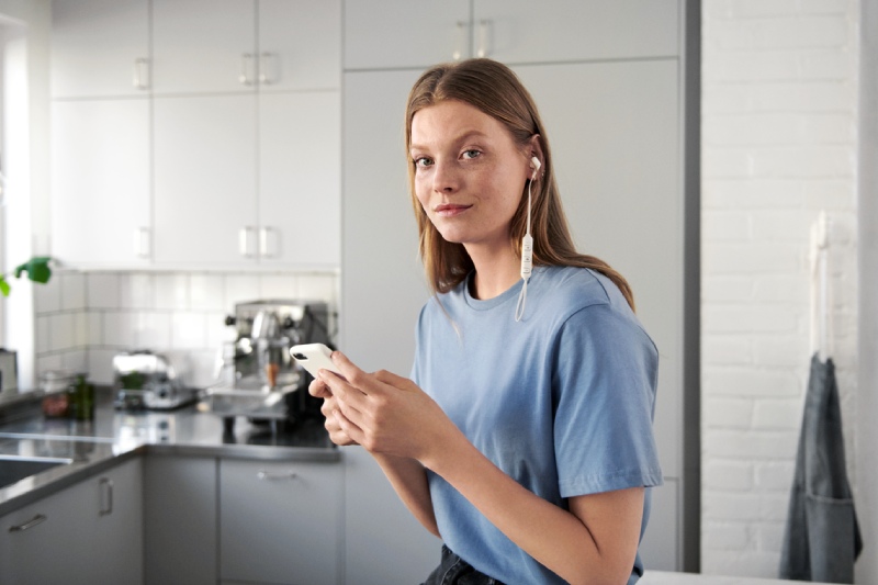 Junge Frau mit Handy und Kopfhörern