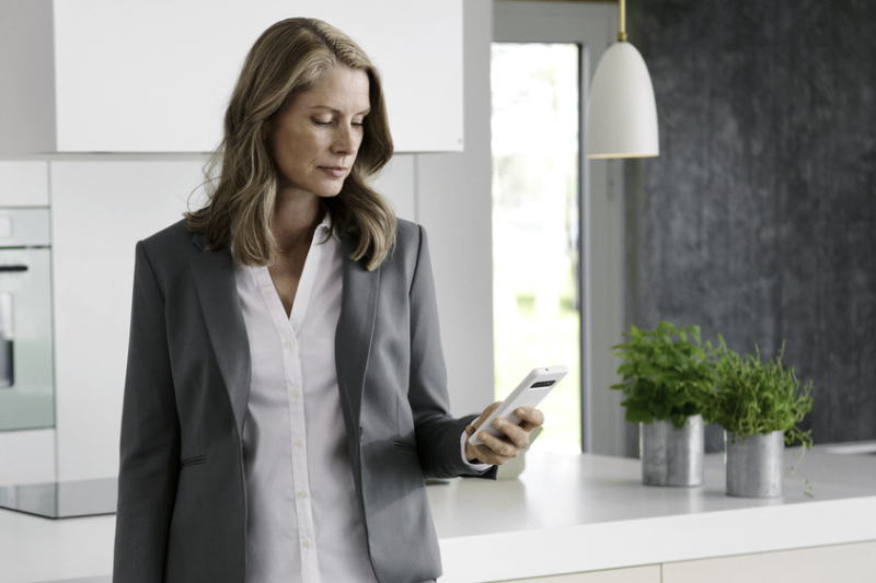 Frau in der Küche mit dem Handy