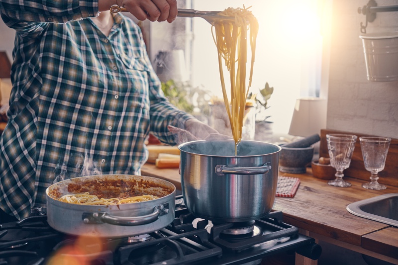 Eine Frau kocht Spaghetti Bolognese