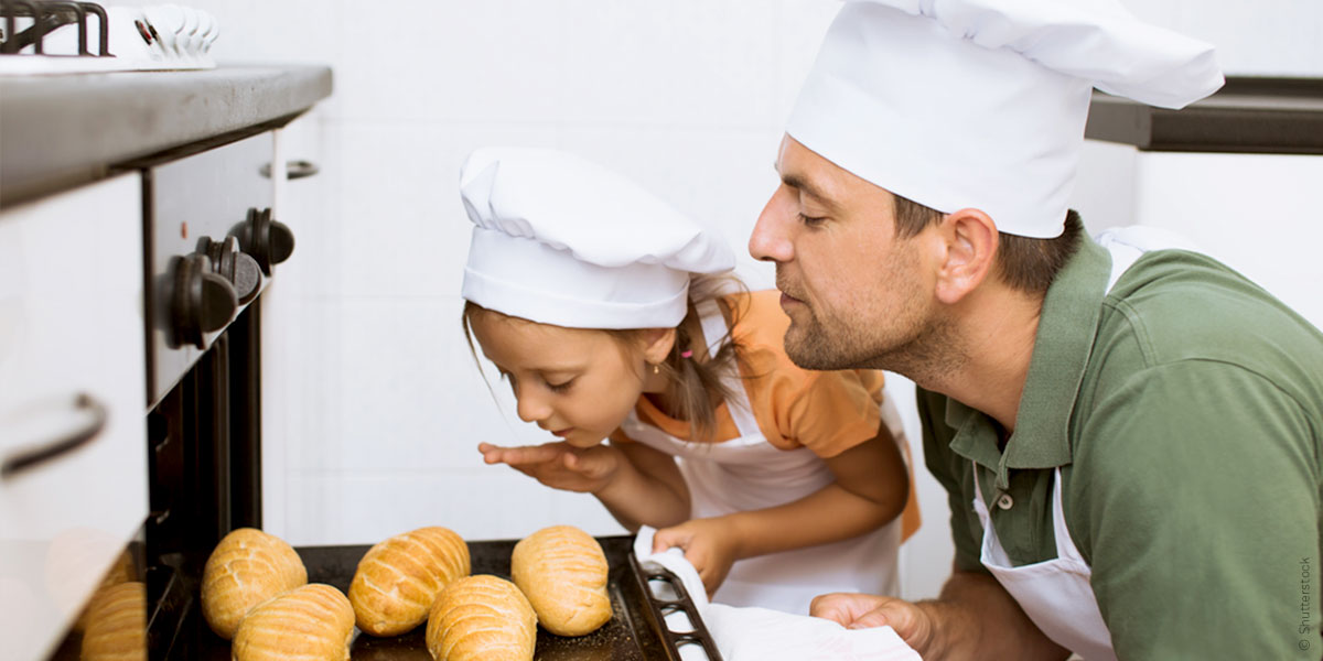 Mann und Kind am Backofen