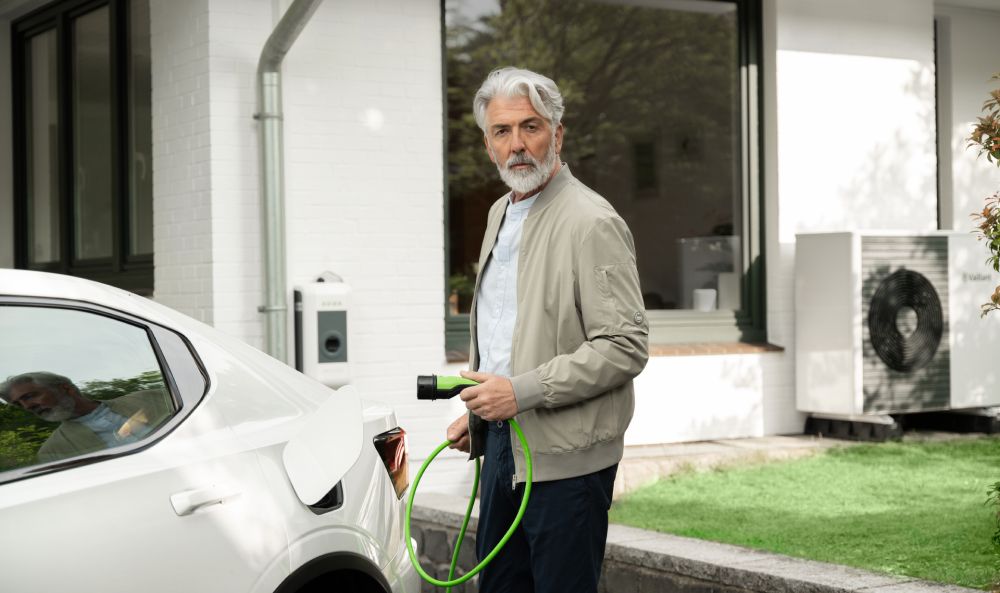 Dieses Bild zeigt einen Mann der ein Elektroauto lädt und verdeutlicht das Thema Dienstwagenbesteuerung