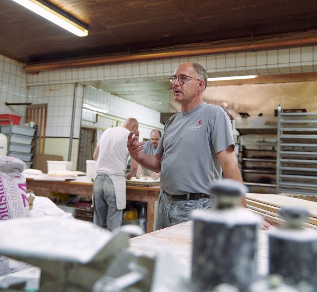 Bild zum Thema Best Practice Mittelstand Energieffizenz - zu sehen ist der Besitzer des Cafe Reinhardts in Hamburg in seiner Backstube - Ein Bild für den Artikel "Was bedeutet Nachhaltigkeit für Unternehmen"