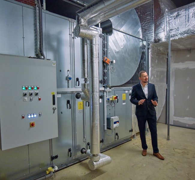 Bild zum Thema Best Practice Mittelstand Resilienz - zu sehen ist der ehemalige Geschäftsführer Michael Weirauch vor der Belüftungsanlage des Möbelhauses - Ein Bild für den Artikel "Was bedeutet Nachhaltigkeit für Unternehmen"