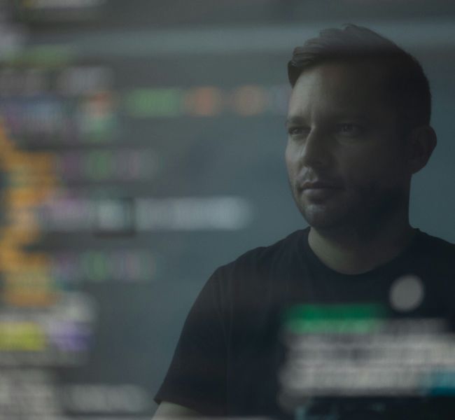 Dieses Bild zeigt einen Mann und Code und verdeutlicht das Thema KI Kompetenzen als Erfolgsfaktor für KMU aufgrund der neuen KI Verordnung