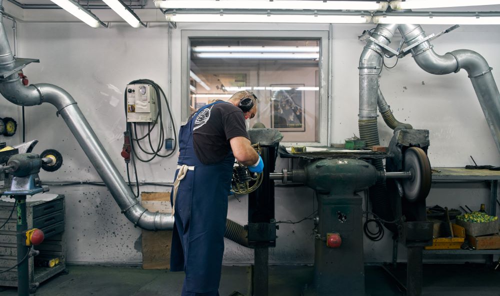 Ein Mann steht an einer Fräse im Unternehmen der Gebrüder Alexander Musikgeräte GmbH