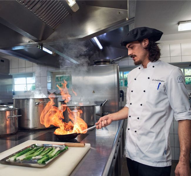 Dieses Bild zeigt einen Koch in der Küche und verdeutlicht das Thema Best Practice im Mittelstand: Hotellerie Landhaus Stricker