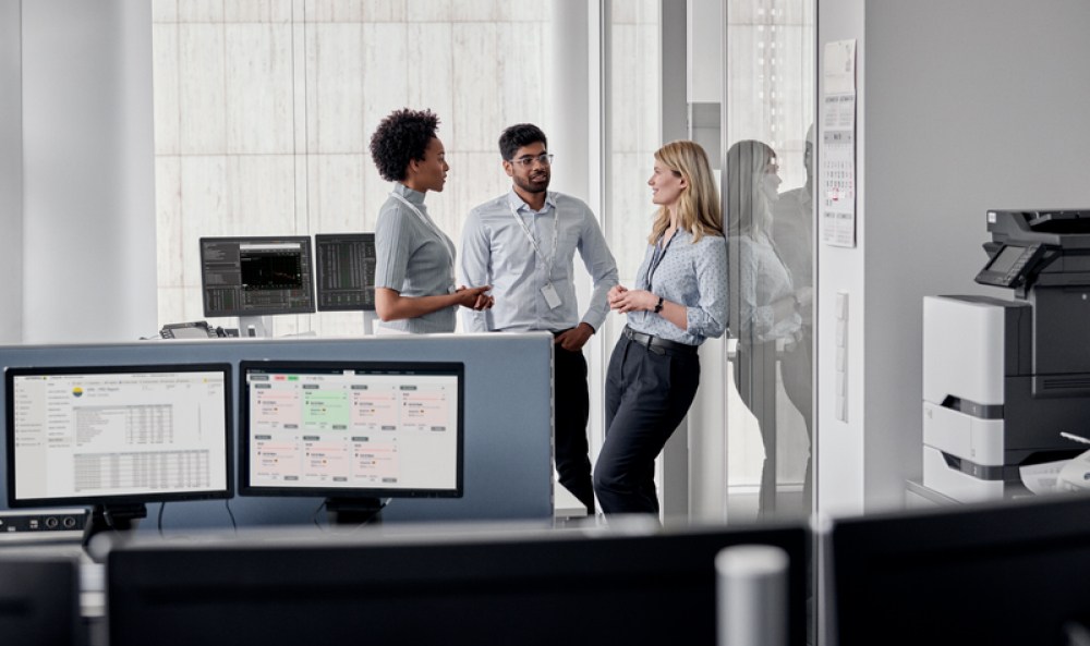 Dieses Bild zeigt Menschen die im Büro diskutieren und ist das TEaserbild für den Artikel Stromsteuer 2025