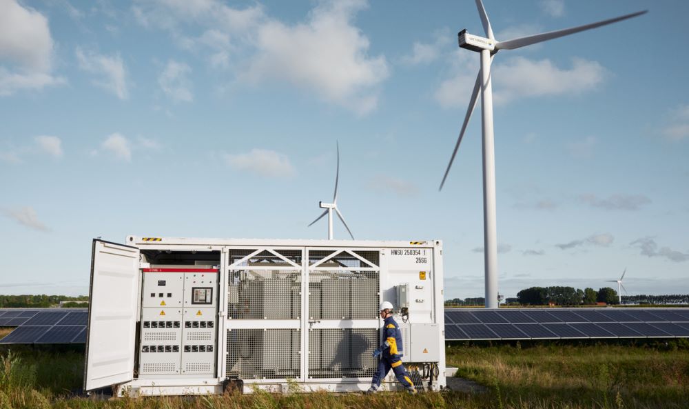 Netzentgelte 2025 - eine Person überprüft an einer Schaltanlage für einem Windenergie-Feld ein Schaltpanel