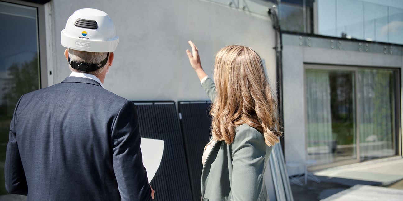 Dieses Bild zeigt einen Mann, eine Frau und eine PV-Anlage und verdeutlicht das Thema Besonderheiten bei der Planung einer PV-Gewerbeanlage