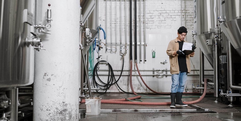 Mann steht in Brauerei.