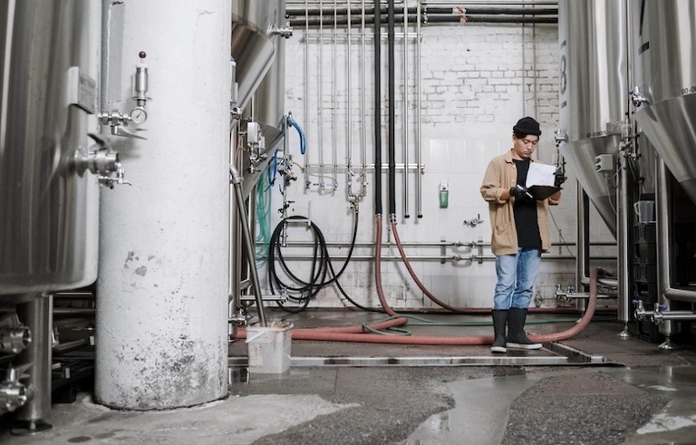 Mann steht in Brauerei.
