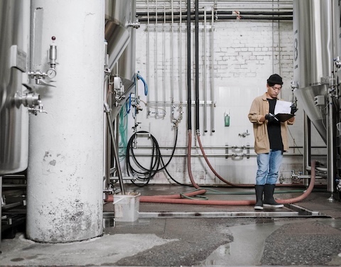 Mann steht in Brauerei.
