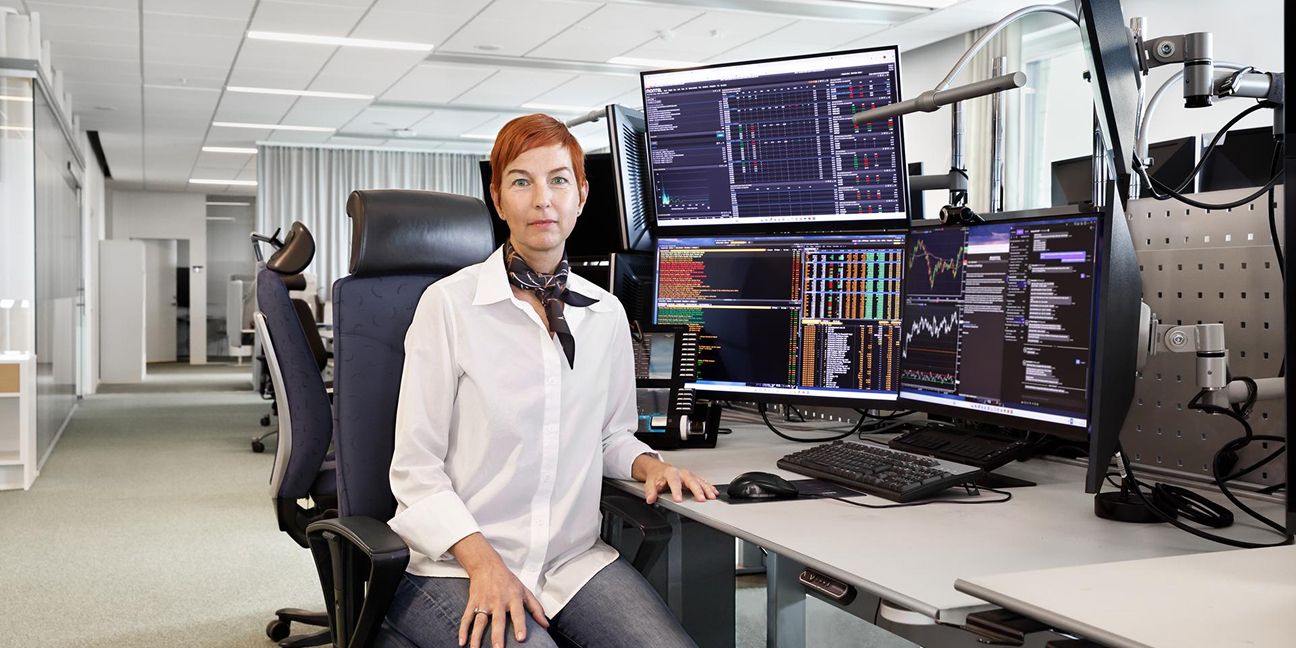 Dieses Bild zeigt eine Frau am Arbeitsplatz mit mehreren Monitoren und verdeutlicht das Thema Strompreisentwicklung 2026