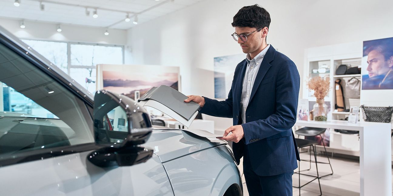 Dieses Bild zeigt einen Arbeiter zwischen Reifen und verdeutlicht das Thema Volvo Autohaus: Das Erfolgsrezept von B&E Automobile