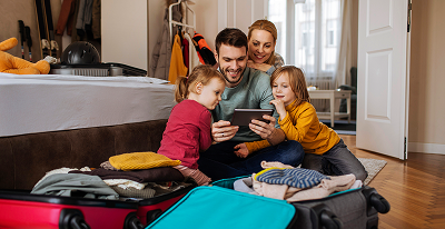 Eine Familie sitzt zusammen und schaut auf ein Ipad