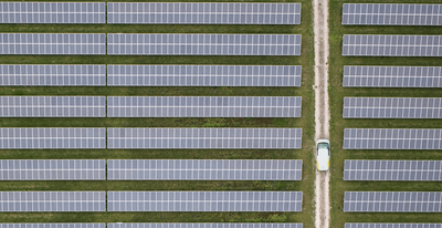 Luftaufnahme von Solarzellen und einem Auto