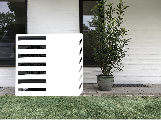 Das Bild zeigt eine Wärmepumpe, die weiß übermalt wurde, um zu demonstrieren, wie sie in die Umgebung integriert und optisch versteckt werden kann. Sie steht vor einer Wand, neben einer Pflanze und auf Rasen.