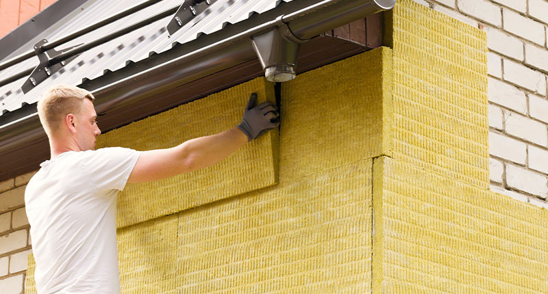 Handwerker dämmt Außenwand