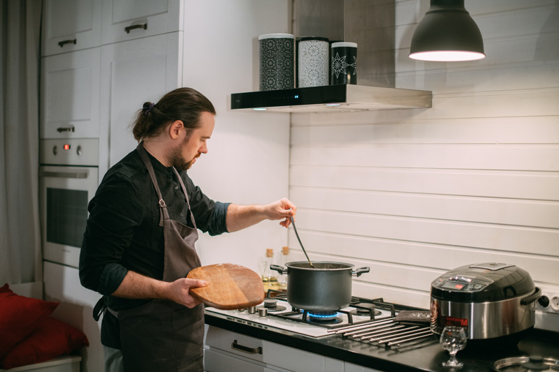 Mann kocht am Gasherd