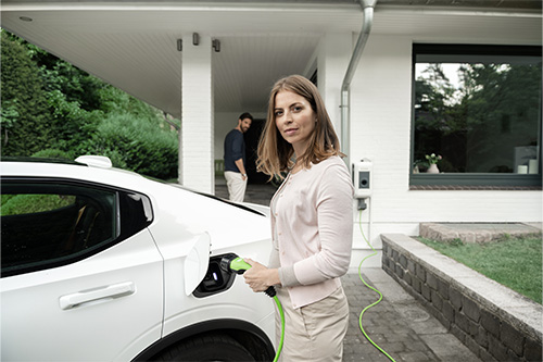 Frau lädt E-Auto