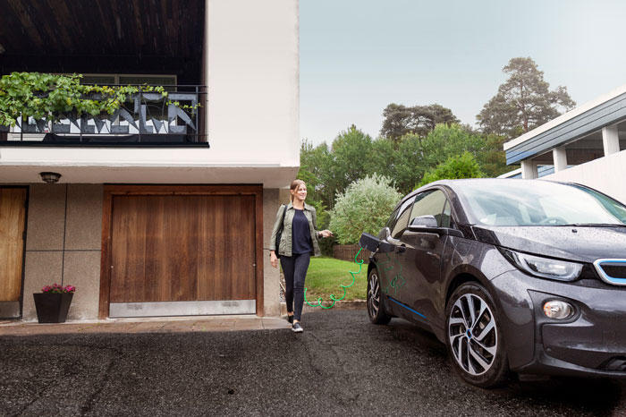 Frau neben E-Auto