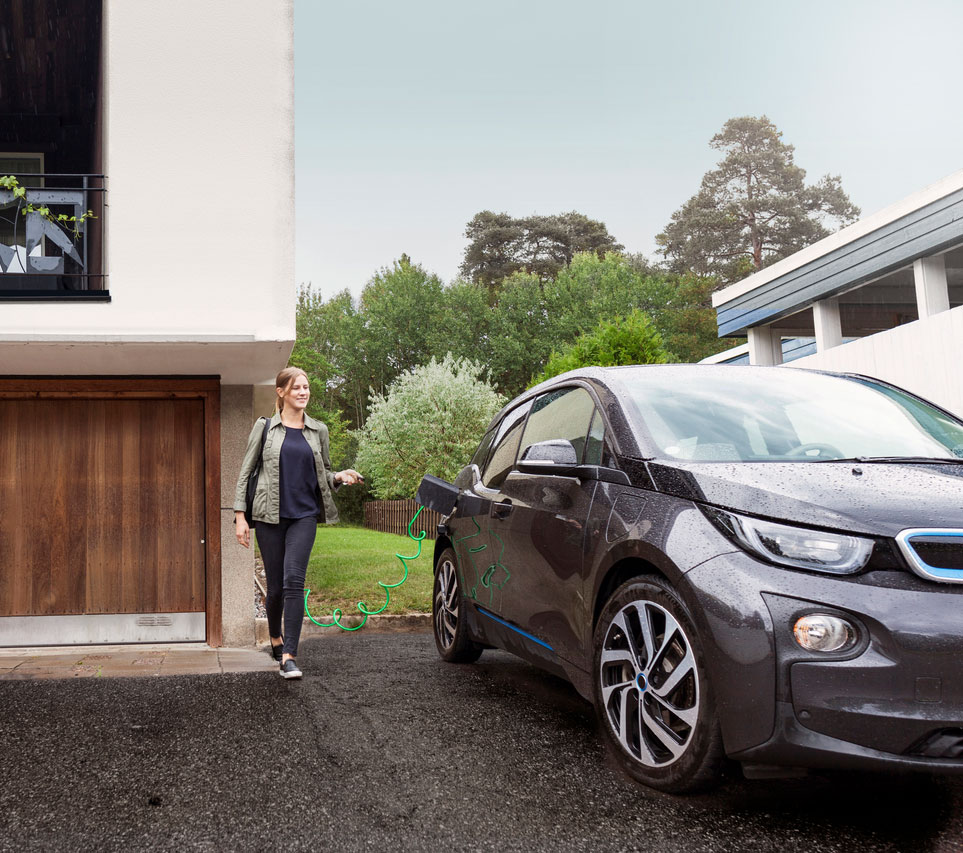 Frau steht neben E-Auto