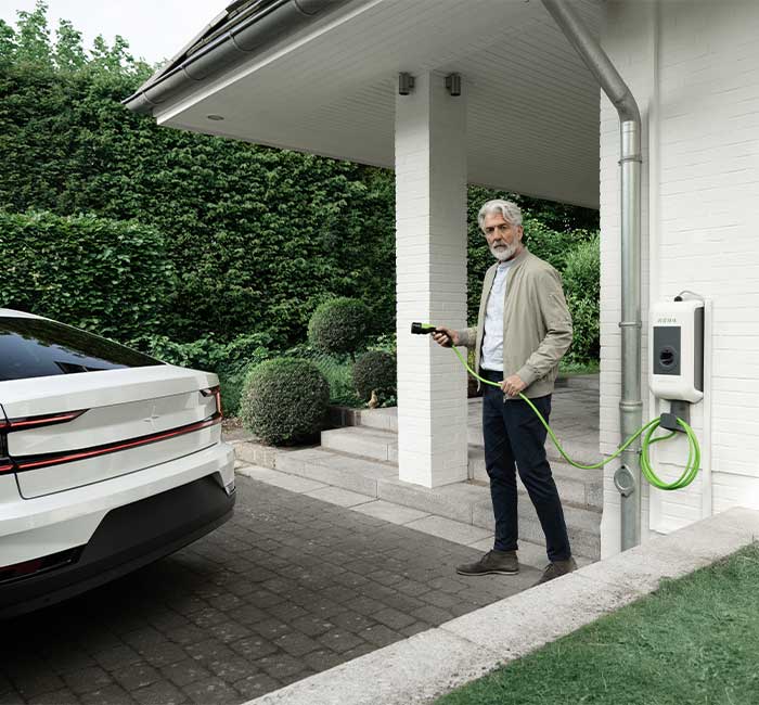 Mann steht neben E-Auto