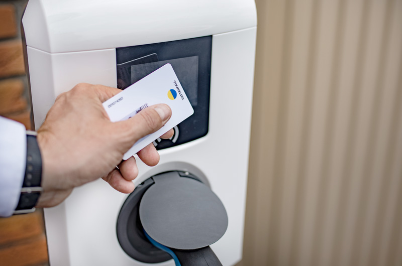 Ladekarte wird an weiße Wallbox gehalten