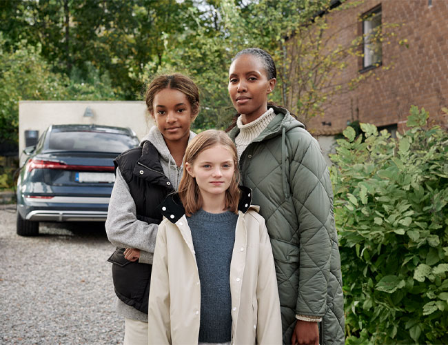 Drei Mädchen vor E-Auto