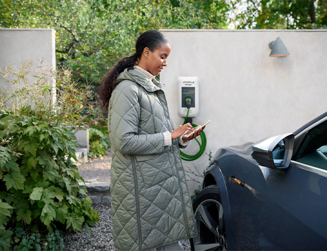 Frau neben E-Auto