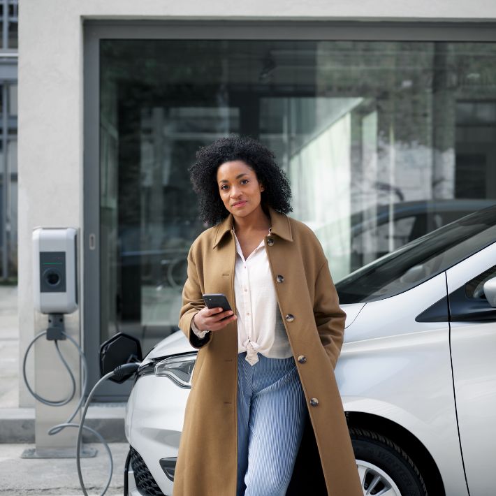 Frau betankt ein E-Auto