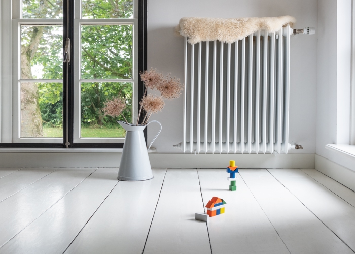 Blick in einen lichtdurchfluteten Altbau mit weißen Dielen