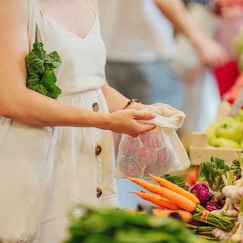 Frau kauft Gemüse ein