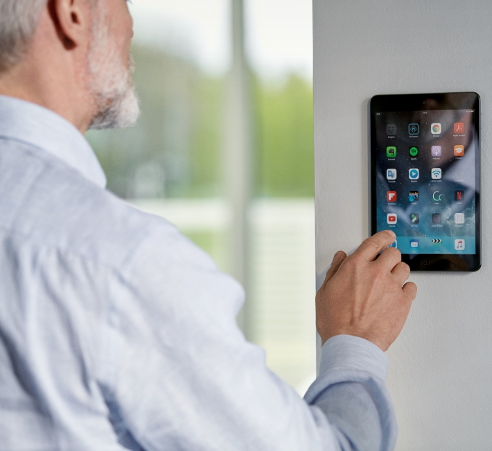 Mann bedient Smart Home Geräte