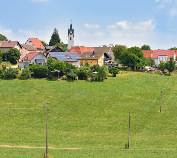 Strommaste vor einem Dorf