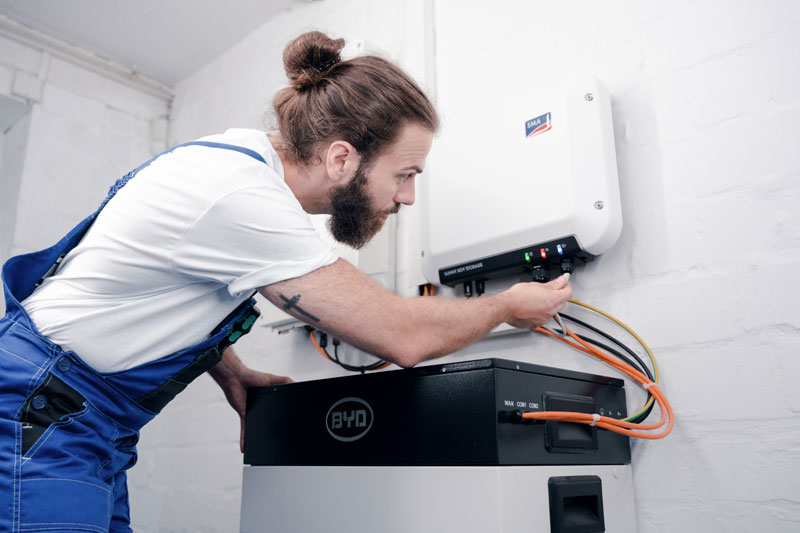 Handwerker schließt Stromspeicher an