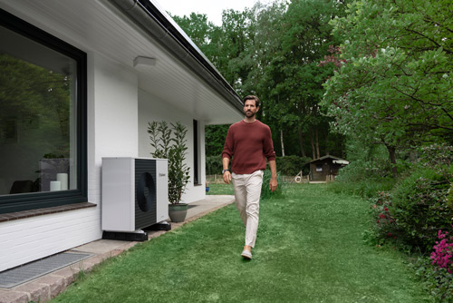 Mann neben Wärmepumpe