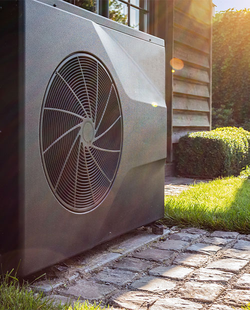 Schwarze Wärmepumpe steht im Garten