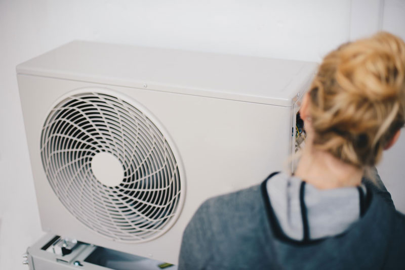 Frau installiert Wärmepumpe