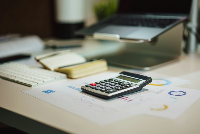 Taschenrechner und Finanzunterlagen auf einem Schreibtisch