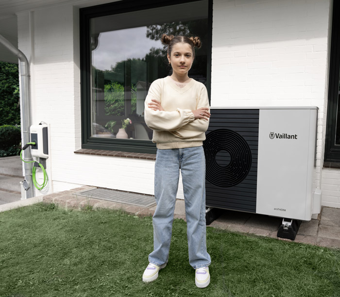 Mädchen steht vor Wärmepumpe
