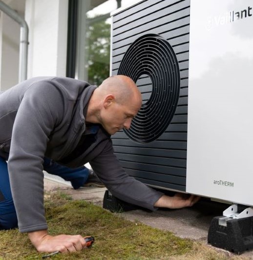 Handwerker installiert Wärmepumpe