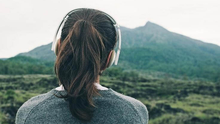 Frau von hinten trägt Bluetooth-Kopfhörer