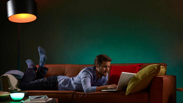 Mann relaxed mit Laptop auf Sofa