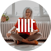 Frau sitzt an Heizung mit Smartphone