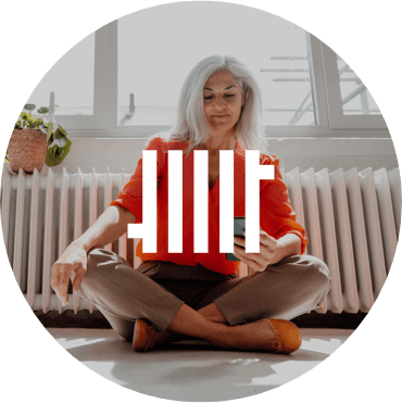 Frau sitzt an Heizung mit Smartphone