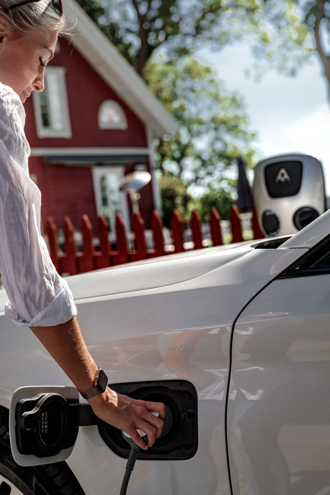 Frau lädt Elektroauto an privater Wallbox
