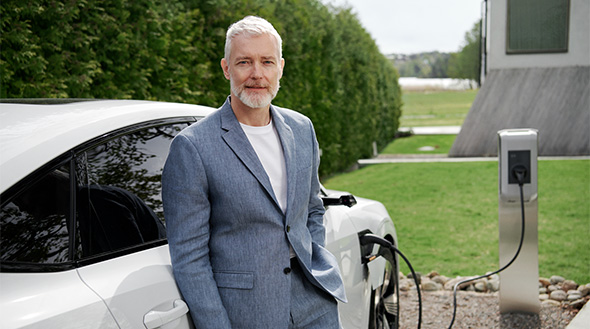 Mann lehnt an E-Auto